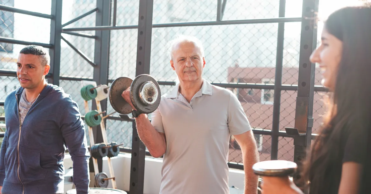 Group of people of different ages lifting dumbbells in a training studio