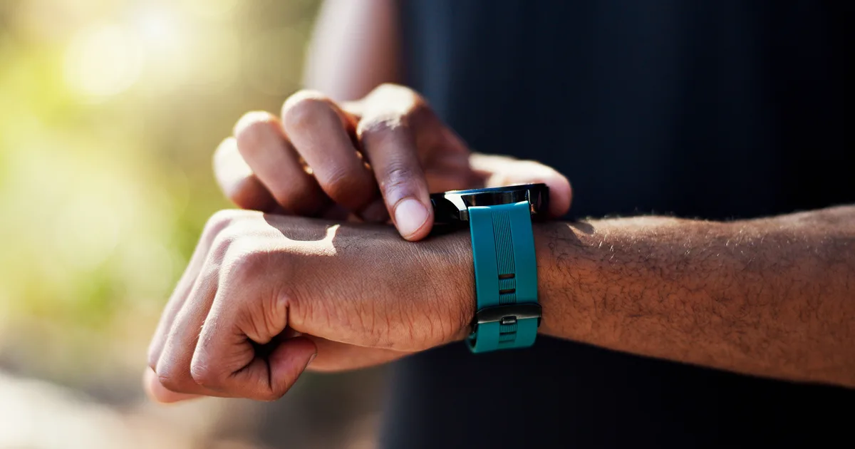 Close-up of a person checking their training progress on a smartwatch outdoors