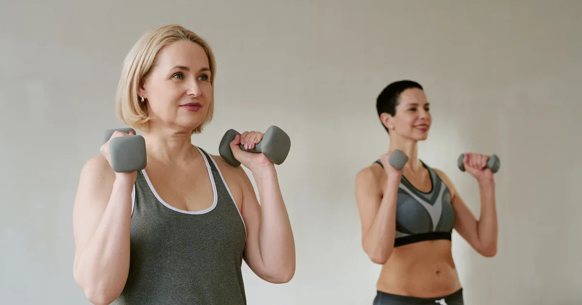 Two middle-aged women doing strength training with dumbbells